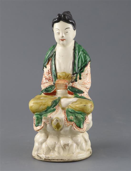 A Chinese Sancai glazed pottery seated figure of Guanyin, Qing dynasty, H.27cm, some flaking to glaze